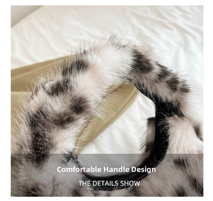 Macro view of leopard print plush crescent bag showing soft round handle and faux fur texture