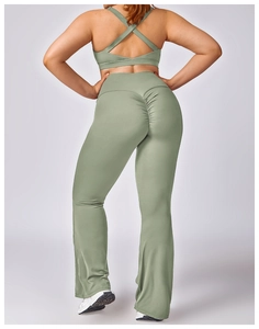 Close-up of sage green flare yoga pants with scrunch butt detail and cross-back sports bra