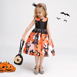 Detail of girls' Halloween pumpkin dress with witch and haunted house print patterns
