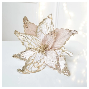 Close-up of champagne gold mesh Christmas poinsettia with glitter petals and soft bokeh background