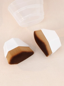 Macro detail of two hexagonal foundation brushes with soft bristles and storage case