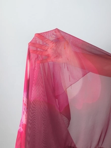 Detail of sheer rose pink mesh fabric with floral print showing breathable texture