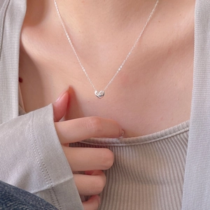 Close-up of minimalist S925 sterling silver heart pendant necklace on female model