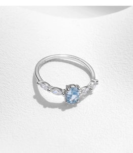 Detailed macro view of S925 silver ring with oval blue crystal and side zircon accents
