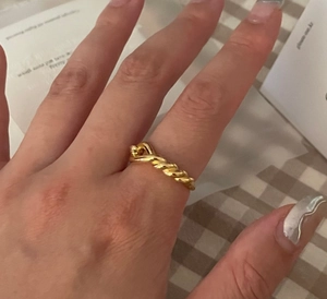 Detailed close-up of a knotted golden 925 silver ring on a hand with vintage style