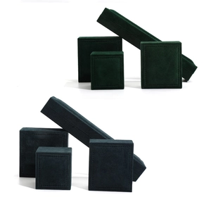 Detail of dark green and navy velvet jewelry boxes showing luxury texture and finish