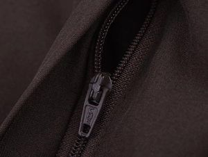 Detail of dark coffee fabric texture and high-quality metal zipper with logo engraving