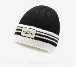 Détail de l'étiquette en cuir Pine Crest sur un bonnet en maille rayé noir et blanc épais