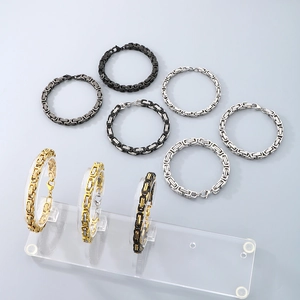 Detailed close-up of Byzantine chain bracelets in gold, silver, and black stainless steel