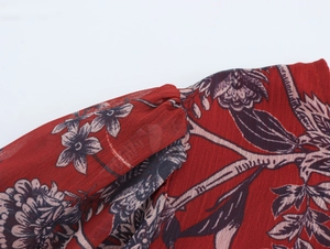 Detail shot of chiffon fabric showing red floral print texture and seam construction