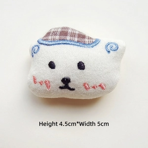 Detail view of small white plush bear with blue embroidery and dimensions H 4.5cm W 5.0cm