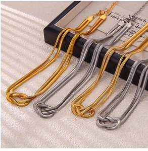 Close-up of double-layer snake chain necklace with punk style knot design in gold and silver
