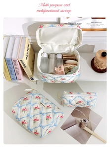Three-piece quilted cosmetic bag set with blue ribbons and pink floral patterns