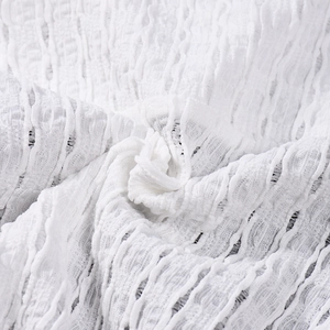 Close-up of white seersucker fabric showing pleated texture and 3D woven structure