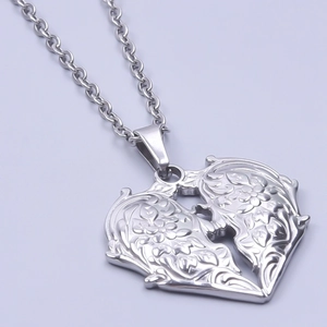 Vue macro d'un pendentif coeur vintage argenté avec gravure florale sur fond violet
