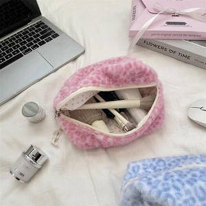 Close-up of pink leopard print plush cosmetic bag showing large interior capacity with brushes