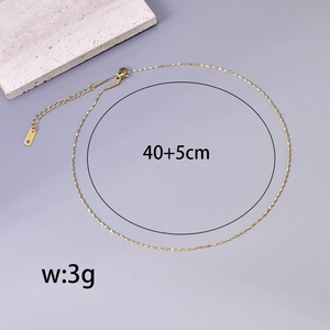 Detail of 40+5cm golden ball necklace with K18 stamp on grey stone background