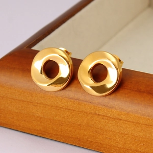 Makroaufnahme von 18K vergoldeten geometrisch gedrehten Spiral-Ohrsteckern mit Glanzfinish