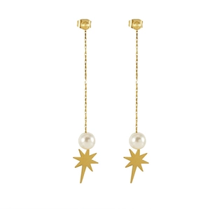 Detailed view of dangling gold star earrings with white pearls and long chain tassels