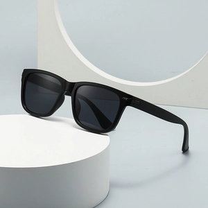 Classic black square frame sunglasses with dark lenses on a minimalist white pedestal