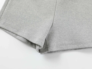 Close-up of light grey knitted fabric texture and premium stitching on yoga shorts