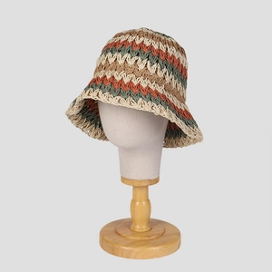 Handmade crochet bucket hat with colorful wavy stripes on a wooden display stand