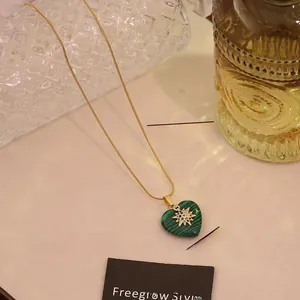 Detailed view of heart malachite pendant necklace with colorful star inlay on snake chain