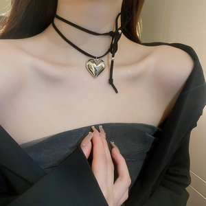Detailed close-up of a 3D silver heart pendant on a black double-layered choker cord