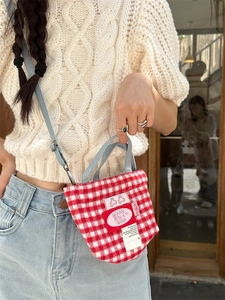 Mini red and white plaid wool tote bag with blue straps and cherry patch on a casual model