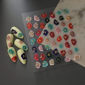 5D embossed nail art stickers with gold letters and crystal accents on white nails