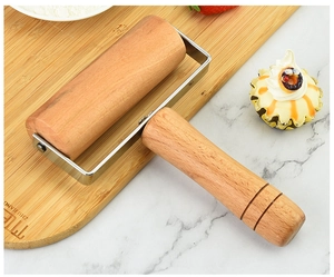 Detail of beech wood rolling pin with metal frame on a floured wooden board