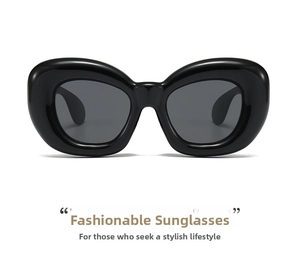 Detail of thick black plastic frame sunglasses with dark grey lenses in retro cat-eye style