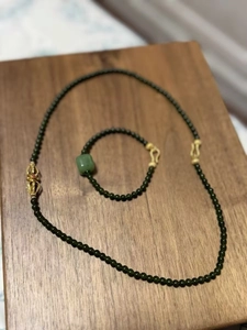Ensemble collier et bracelet en perles de jade vert foncé avec un accent de vajra doré