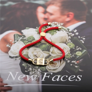 Adjustable red rope bracelet with gold metal plate and rhinestone letter G on magazine