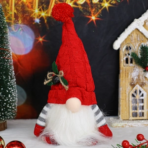 Close-up of a festive Christmas gnome with a red knitted hat and warm holiday background