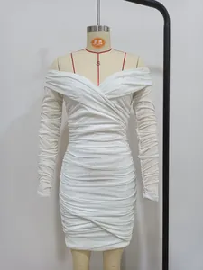 Dettaglio dell'abito bianco con spalle scoperte, increspature, strass e maniche lunghe