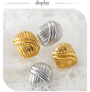 Macro detail of gold and silver textured earrings with woven metal pattern and PVD coating