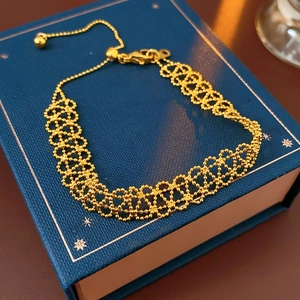 Detailed close-up of gold-plated woven mesh bracelet with adjustable sliding clasp