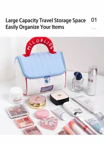 Dettaglio del beauty case trapuntato blu con manico rosso e doppia cerniera per il viaggio