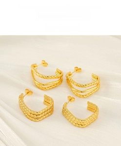 Detailed view of gold stainless steel C-shape hoops and twisted rope earring textures