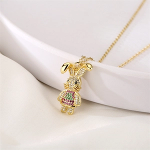 Macro detail of golden bunny pendant with colorful zircon crystals on silk fabric