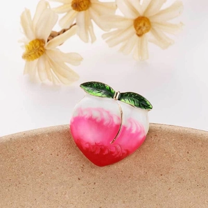 Detailed close-up of a peach fruit enamel brooch with red gradient and golden trim