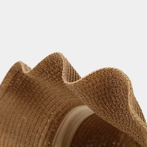 Macro shot of wavy brim detailing and fine weave texture on a straw cowboy hat