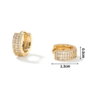 Detail showing 1.3cm gold huggie earrings with triple-row micro-pave cubic zirconia