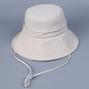 Detail of beige sun hat featuring wide brim, sturdy canvas fabric and adjustable wind cord