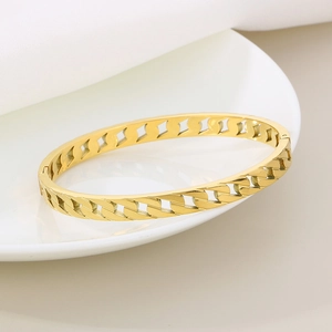 Elegant gold hollow chain bracelet in stainless steel on a white ceramic plate