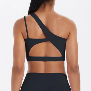 Detail of black asymmetric sports bra with cut-out back design and brushed texture