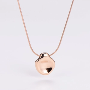 Macro shot of rose gold snake chain and irregular concave pebble pendant with mirror finish