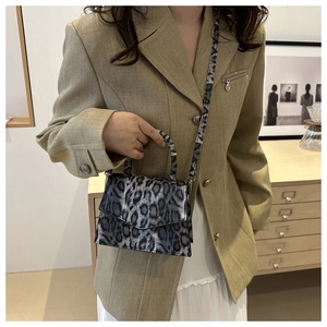 Fashionable leopard print handbag with detachable strap styled on a model outfit