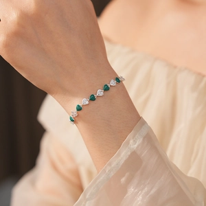 Elegant French vintage bracelet with green heart stones and white zircon details on wrist